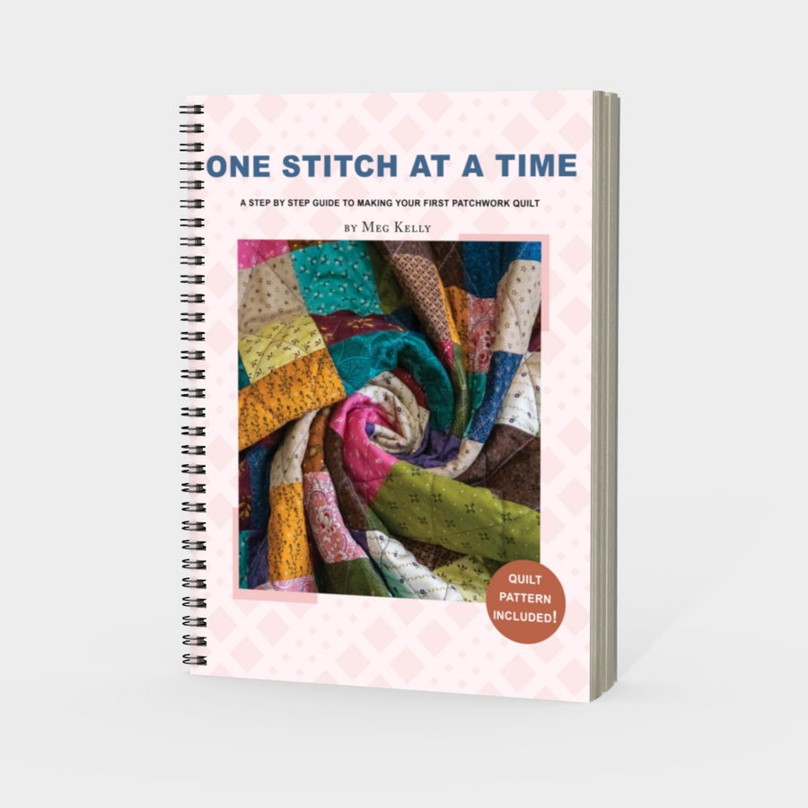 Book titled 'One Stitch at a Time' with colourful quilt image on cover